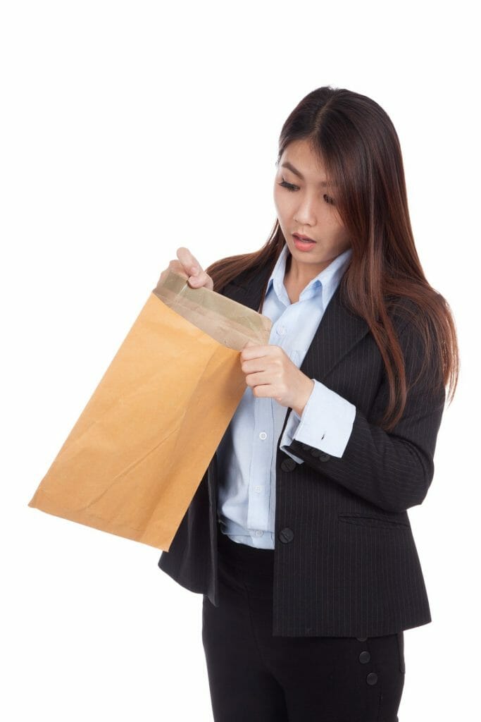 Young Asian businesswoman surprise look inside brown envelopes