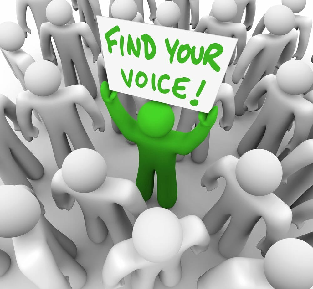 Find Your Voice Man Holding Sign in Crowd – Confidence